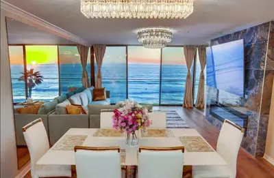 a dining room with a table with flowers on it at Panoramic Ocean Views Beach & Boardwalk Access in San Diego