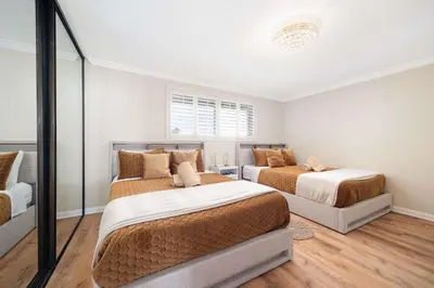 a bedroom with two beds and a couch at Panoramic Ocean Views Beach & Boardwalk Access in San Diego