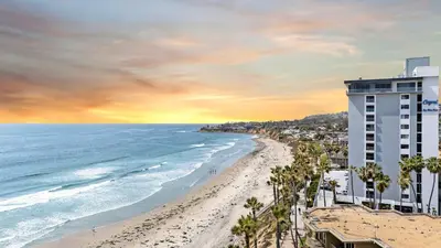 a view of a beach with a building and the ocean at Panoramic Ocean Views Beach & Boardwalk Access in San Diego