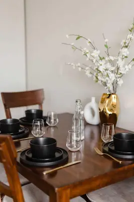 a wooden table with black plates and glasses on it at Upscale Modern Spacious Loft in Little Italy in San Diego