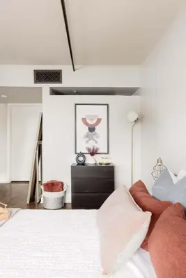 a bedroom with a large white bed with red pillows at Upscale Modern Spacious Loft in Little Italy in San Diego
