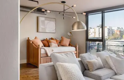 a living room with two beds and a large window at Upscale Modern Spacious Loft in Little Italy in San Diego