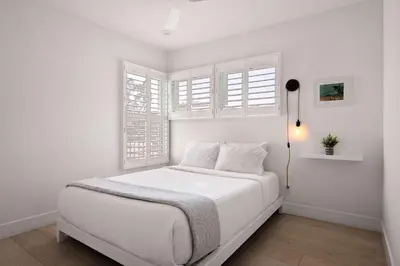 a white bedroom with a white bed with windows at Inviting 3BR Near Mission Beach in San Diego