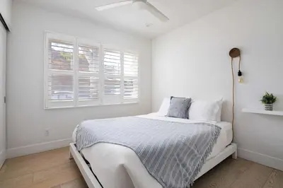 a white bedroom with a bed and two windows at Inviting 3BR Near Mission Beach in San Diego