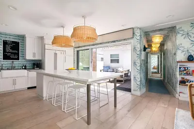 a kitchen with a large white table and stools at Inviting 3BR Near Mission Beach in San Diego