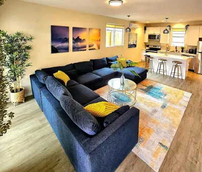 a living room with a blue couch and a kitchen at Heights Golden Luxe Retreat in San Diego