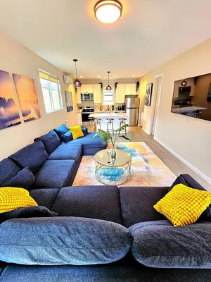 a living room with a blue couch and yellow pillows at Heights Golden Luxe Retreat in San Diego