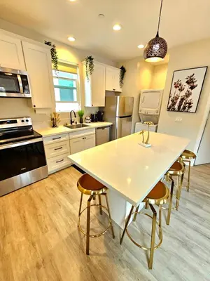 a kitchen with a large white table and chairs at Heights Golden Luxe Retreat in San Diego