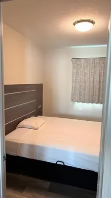 a small bedroom with a bed and a window at Broadway Inn and Suites in Chula Vista