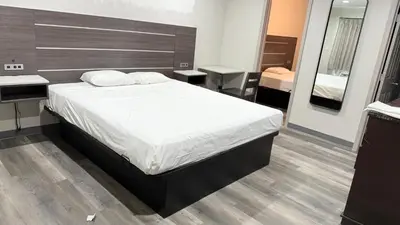 a bedroom with a large bed with a wooden headboard at Broadway Inn and Suites in Chula Vista