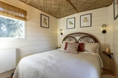 a bedroom with a white bed with pillows and a window at Vintage Tiny House with Spa-Inspired Bathroom in Warner Springs, California in Warner Springs