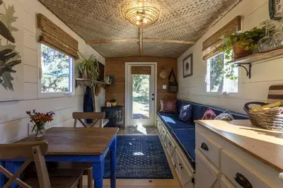 a tiny house with a blue couch and a table at Vintage Tiny House with Spa-Inspired Bathroom in Warner Springs, California in Warner Springs