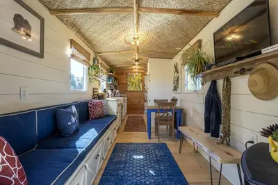 a living room with a blue couch and a table at Vintage Tiny House with Spa-Inspired Bathroom in Warner Springs, California in Warner Springs