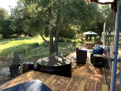 a patio with a table and chairs on a deck at Vintage Tiny House with Spa-Inspired Bathroom in Warner Springs, California in Warner Springs