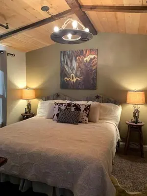 a bedroom with a large bed with two lamps at Unique Western-Themed Cabin Rental for Secluded Getaway in Warner Springs, California in Warner Springs