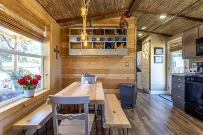 a kitchen with a wooden table in a tiny house at Unique Western-Themed Cabin Rental for Secluded Getaway in Warner Springs, California in Warner Springs