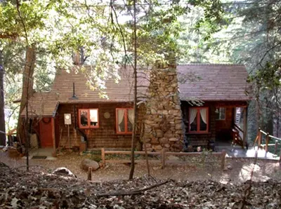 a small stone house in the middle of the woods at Historic Holiday Redwood Cabin in Palomar Mountain, California in Palomar Mountain