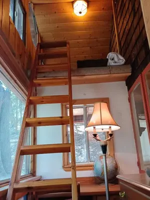 a staircase in a tiny house with a lamp at Historic Holiday Redwood Cabin in Palomar Mountain, California in Palomar Mountain