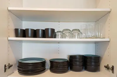 a bunch of plates and glasses on a shelf at Lux North Park Gem King Beds Workspaces Parking in San Diego