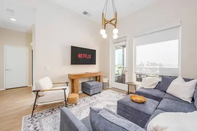 a living room with a couch and a tv at North Park Penthouse King Beds Workspaces Parking in San Diego