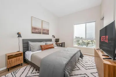 a bedroom with a bed and a flat screen tv at North Park Penthouse King Beds Workspaces Parking in San Diego
