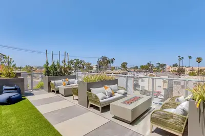 a patio with couches and chairs on a roof at North Park Penthouse King Beds Workspaces Parking in San Diego