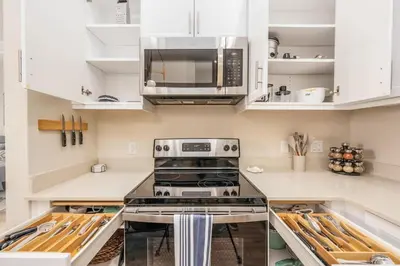 a kitchen with a stove and a microwave at North Park Penthouse King Beds Workspaces Parking in San Diego
