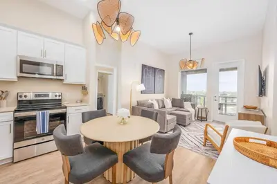 a kitchen and living room with a table and chairs at Lux N Park Penthouse King Beds Workspaces Parking in San Diego