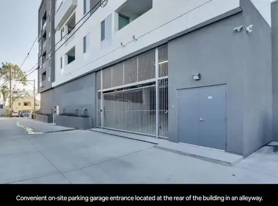 a building with a gate parking garage located at the rear of the building at Lux N Park Penthouse King Beds Workspaces Parking in San Diego
