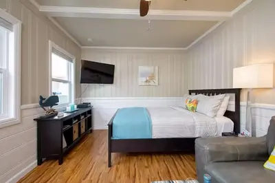 a bedroom with a bed and a tv and a couch at Steps to Newport Harbor Balboa Fun Zone Dock Access Edgewater Studios in Newport Beach