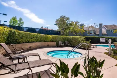 a patio with a pool with chairs and a fountain at Carmel Valley 2BR with Amenities in San Diego