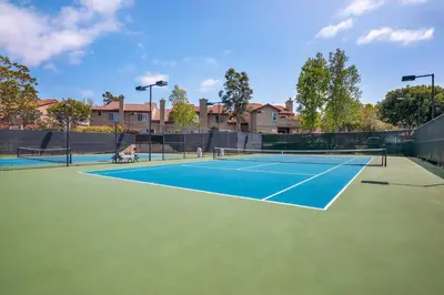 a tennis court with two people on it at Carmel Valley 2BR with Amenities in San Diego