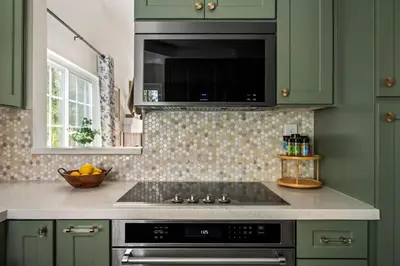 a kitchen with green cabinets and a stove top oven at Carmel Valley 2BR with Amenities in San Diego