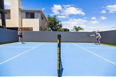 two people playing tennis on a tennis court at Stunning Bay Views with Pickleball and Hot Tub in San Diego