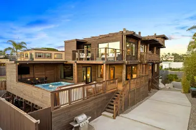 a large house with a deck and a swimming pool at Stunning Bay Views with Pickleball and Hot Tub in San Diego