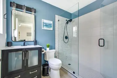 a bathroom with a toilet and a glass shower at Tower 9 Oceanview House in Oceanside
