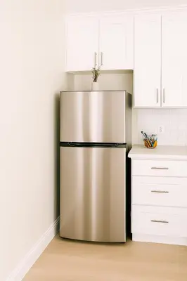 a stainless steel refrigerator in a kitchen with white cabinets at Terracotta Casita in San Diego
