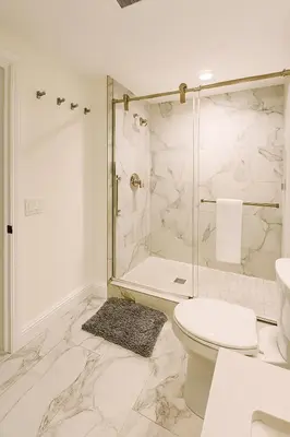 a white bathroom with a shower and a toilet at Terracotta Casita in San Diego