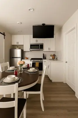 a kitchen with a table and a kitchen with white cabinets at Terracotta Casita in San Diego