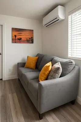 a living room with a gray couch with pillows at Terracotta Casita in San Diego