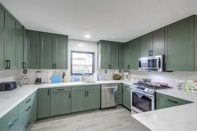a green kitchen with green cabinets and appliances at Entire Private Home with 3 Bedrooms 2 Bathrooms, Gated Yard, 100 inch TV, 1 Gbps WiFi, Available Now in San Diego