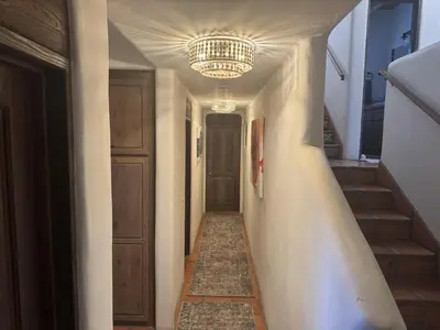 a hallway with a chandelier and a hallway with stairs at Luxury 5 bedroom Wine Retreat Fallbrook Villa sleeps 12 in Fallbrook