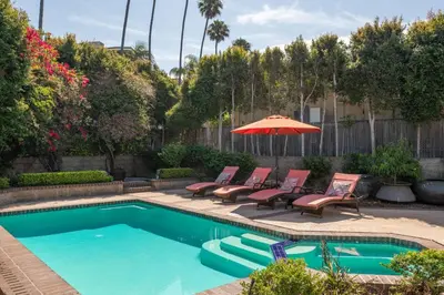 a swimming pool with chairs and an umbrella and an umbrella at Bird Rock Dream - Pool, Spa, and Stunning Ocean View! in San Diego