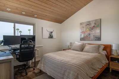 a bedroom with a bed and a desk with a computer at Bird Rock Dream - Pool, Spa, and Stunning Ocean View! in San Diego