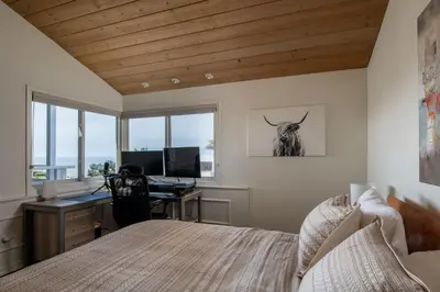 a bedroom with a bed and a desk with a computer at Bird Rock Dream - Pool, Spa, and Stunning Ocean View! in San Diego
