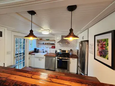 a kitchen with stainless steel appliances and two pendant lights at Urban Oasis Near Downtown & Balboa Park in San Diego