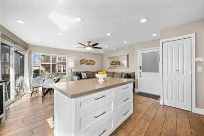 a kitchen with white cabinets and a dining room at Oceanview Steps to Beach AC Parking! in Newport Beach