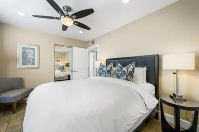a bedroom with a white bed and a ceiling fan at Oceanview Steps to Beach AC Parking! in Newport Beach