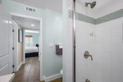 a bathroom with a shower and a bedroom at Oceanview Steps to Beach AC Parking! in Newport Beach
