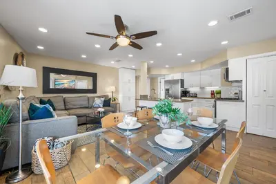 a living room with a dining table and a kitchen at Steps to Beach AC Parking Beach Equipment in Newport Beach
